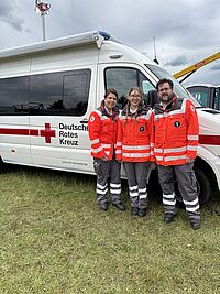 Amelie Oesterreich und ihre Eltern stehen vor einem Einsatzwagen des DRK.