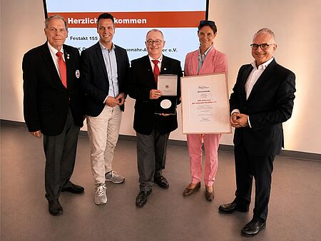 Gruppenfoto mit 5 Personen, Michael Assenmacher zeigt die Henry-Dunant-Plakette.
